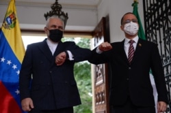 FILE - The Foreign Minister of the Islamic Republic of Iran, Javad Zarif, left, bumps elbows with Venezuelan Foreign Minister Jorge Arreaza at the Casa Amarilla palace in Caracas, Nov. 5, 2020.