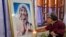 An Indian Catholic woman offers prayers as she touches a portrait of Mother Teresa on her 17th death anniversary at the Missionaries of Charity in Kolkata, India, Sept. 5, 2014.