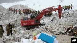 This picture made available Jan. 24, 2017 by the Italian Mountain Rescue Service 'Corpo Nazionale Soccorso Alpino e Speleologico' shows an excavator at the site of the avalanche-buried Hotel Rigopiano, near Farindola. Italy.