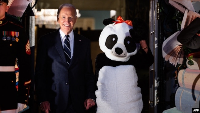 President Joe Biden, second from left, stands with first lady Jill Biden — in a panda costume — at a Halloween event at the White House in Washington, Oct. 30, 2024.