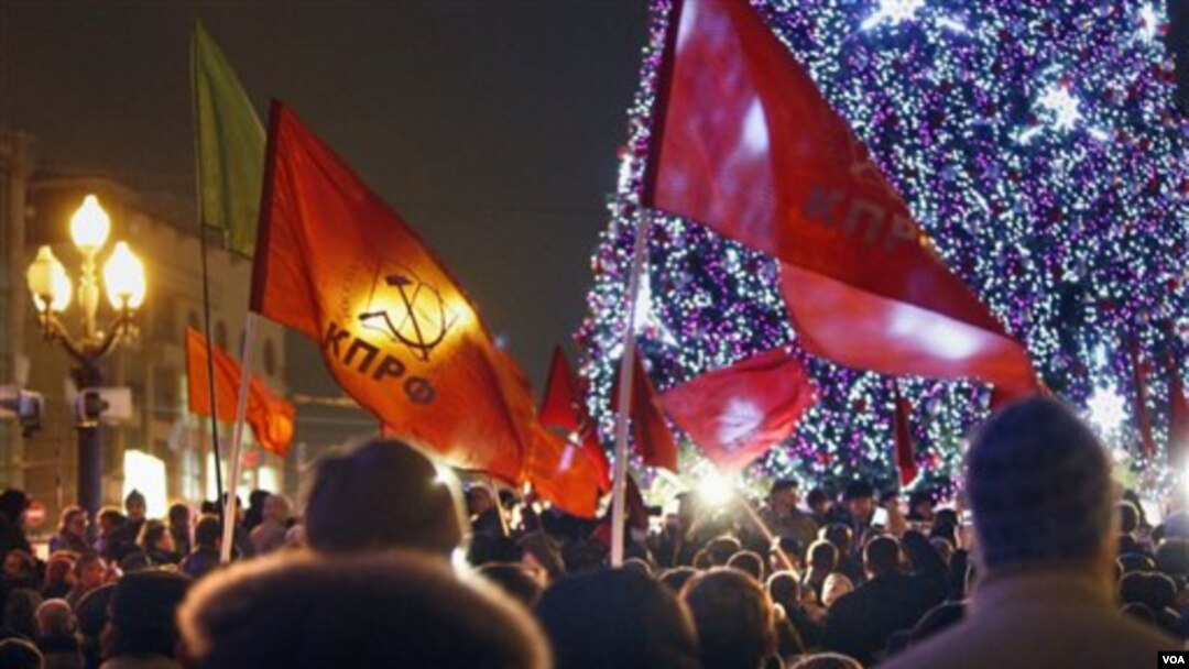 Partai Komunis Rusia melambaikan bendera partainya dalam aksi protes terkait hasil pemilu Rusia di Moskow (5/12).