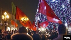 Partai Komunis Rusia melambaikan bendera partainya dalam aksi protes terkait hasil pemilu Rusia di Moskow (5/12).