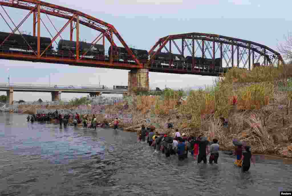 Asylum seekers wait on the banks of the Rio Bravo river after crossing during their journey through Mexico to Eagle Pass, Texas, in Piedras Negras, Mexico, Sept. 26, 2023.