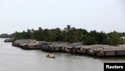 A motorboat moves past a row of empty houseboats in a tributary of the Pamba river following floods in Alappuzha district in the southern state of Kerala, India, Aug. 24, 2018. 