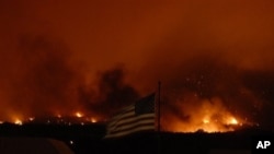 Structures burn in the Waldo Canyon wildfire, creating a glow above the western side of Colorado Springs, Colo., June 26, 2012.