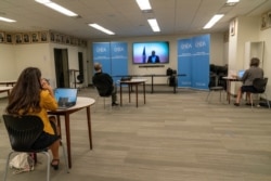 Members of the media observe social distancing as they watch a video link in the United Nations Correspondents Association office, Sept. 21, 2020, at United Nations headquarters.