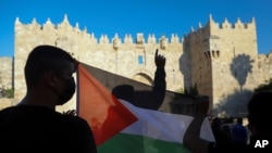 FILE - Palestinians demonstrators wave the Palestinian flag during protest in Damascus gate just outside Jerusalem's Old City. 