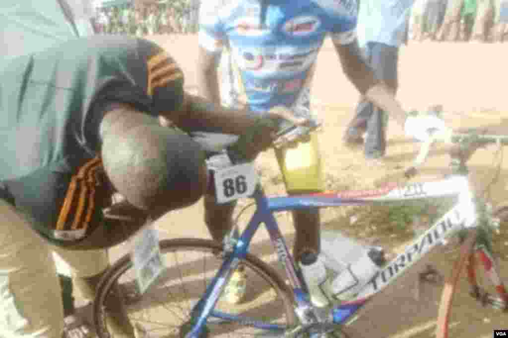 Un cycliste malien essaie de regler son vélo lors de la 5e étape entre Pa et Bobo-Dioulasso, 3 nov. 2015. Photo Salif kaboré.