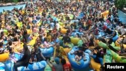 Para pengunjung memadati kolam renang saat liburan Idul Fitri, di Bogor, Jawa Barat, 18 Juni 2018. (Foto: Antara via Reuters)