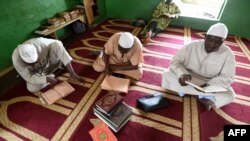 Les musulmans lisent un Coran après une prière du vendredi dans une mosquée d'Abidjan pendant le mois sacré du Ramadan, le 18 mai 2018 