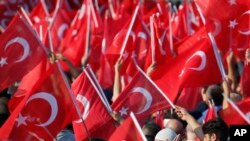 Orang-orang melambaikan bendera dalam pawai untuk mengenang korban kudeta gagal 15 Juli 2016, di Istanbul, Turki, 15 Juli 2019.