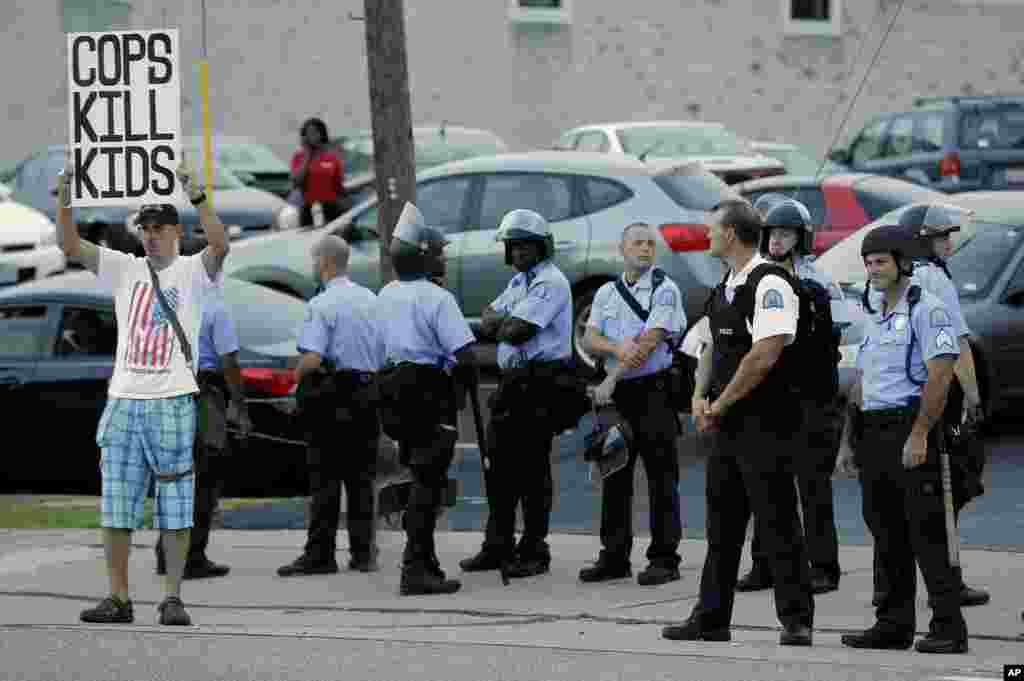 A man protests the police shooting death of Michael Brown a week ago in Ferguson, Aug. 16, 2014.