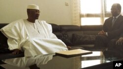 Mali's ousted President Amadou Toumani Toure (L) sits with Djibril Bassole, Burkina Faso's foreign minister and one of the leading mediators for West Africa's ECOWAS bloc, during a meeting in which Toure resigned in the capital Bamako, April 8, 2012. 