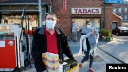 A man wearing a face mask carries a tobacco boxes after purchasing at the Macquenoise border post as France reopens its borders with its European neighbours after the lockdown to prevent the spread of the coronavirus disease (COVID-19) outbreak, in Macquenoise, Belgium June 15, 2