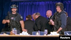 U.S. President Donald Trump is escorted out of the White House Correspondents' Association (WHCA) dinner in Washington