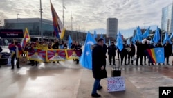 Activists supporting Tibet and the Uyghur minority in China protest against what they consider unfair Chinese government policies outside the U.N. office in Geneva, Switzerland on January 23, 2024. (AP Photo/Jamey Keaten)