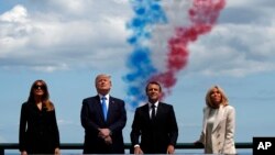 Les couples présidentiels, Melania et Donald Trump, Brigitte et Emmanuel Macron lors d'une cérémonie commémorant le 75e anniversaire du jour J au cimetière américain de Normandie, à Colleville-sur- Mer, le 6 juin 2019.