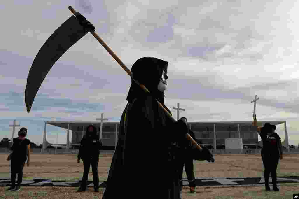 A demonstrator dressed as Death performs outside Planalto presidential palace to protest the president&#39;s handling of the COVID-19 pandemic in Brasilia, Brazil. Brazil surpassed 300,000 deaths from the virus this week.