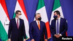 FILE - Hungary's Prime Minister Viktor Orban, Poland's Prime Minister Mateusz Morawiecki and Italy's League party leader Matteo Salvini pose for a picture after a news conference following their meeting in Budapest, Hungary, Apr. 1, 2021.