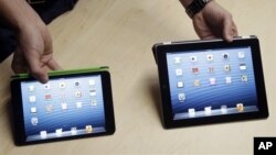 iPad Mini (kiri), dengan layar dua pertiga dan bobot setengah dari iPad generasi keempat. (AP/Marcio Jose Sanchez)