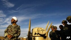 FILE - An Iranian clergyman stands next to missiles and army troops, in an undisclosed location in Iran, Nov. 13, 2012. (AP)