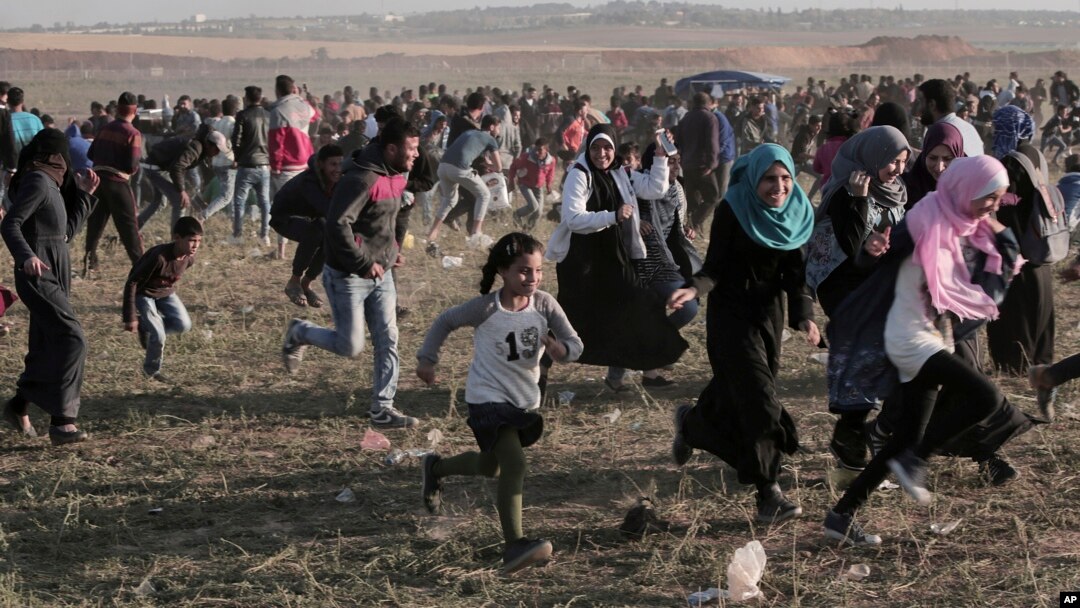 Palestinski učesnici demonstracija beže od suzavca koji su ispalil izraelski vojnici, Pojas Gaze 31. mart 2018. (AP Photo/Adel Hana)