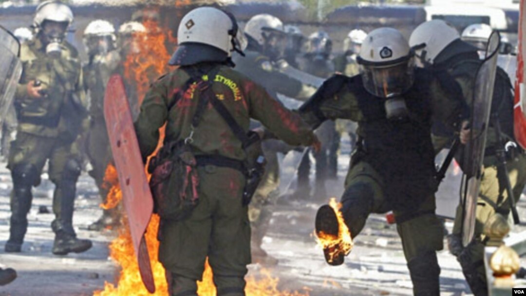 Pasukan keamanan Yunani memadamkan kebakaran akibat bom molotov yang dilemparkan para demonstran di Athena yang memrotes langkah-langkah penghematan (19/10).
