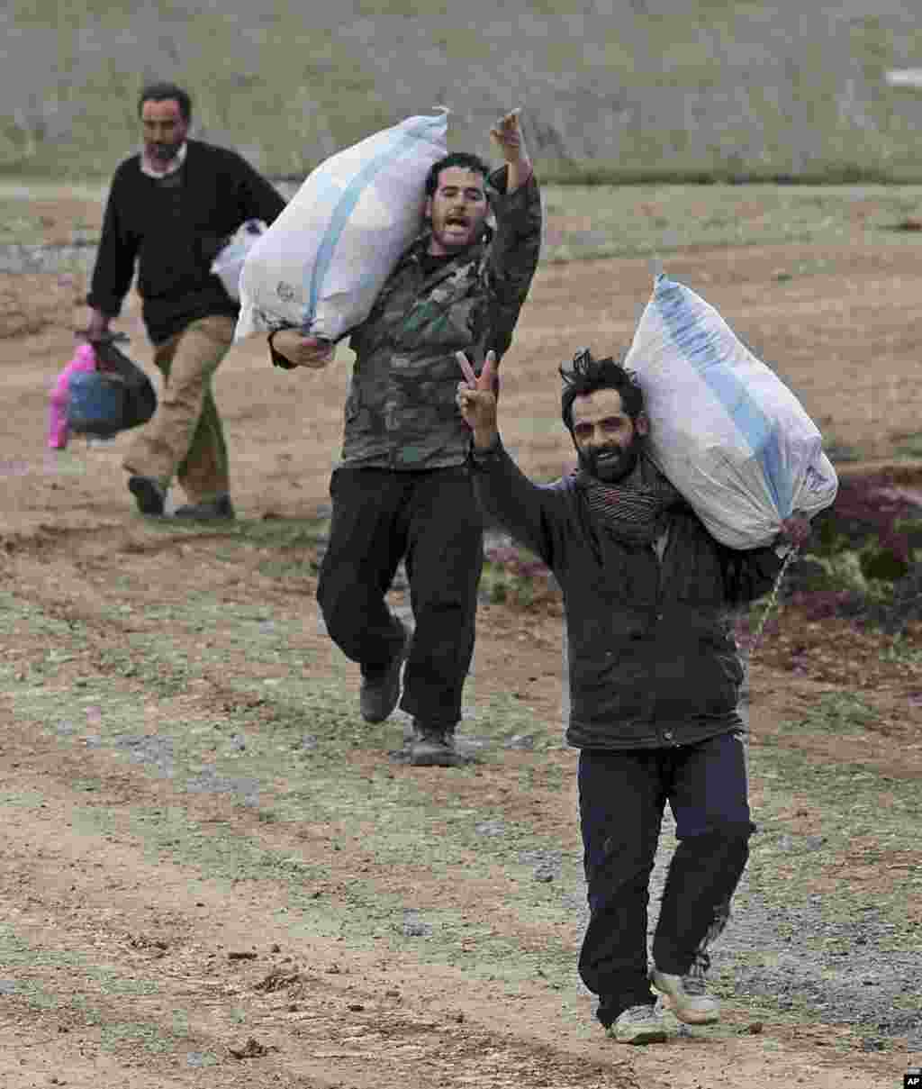 A group of Syrians fleeing violence in their country walk towards the Turkish border near Reyhanli, Turkey, March 15, 2012. (AP)