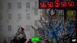 FILE - A woman passes a currency exchange in Moscow, Dec. 12, 2014.