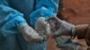 Un trabajador de salud se limpia las manos con desinfectante luego de tomar una muestra a un paciente en un centro de pruebas de covid en Hyderabad, India, el domingo 11 de octubre de 2020. 