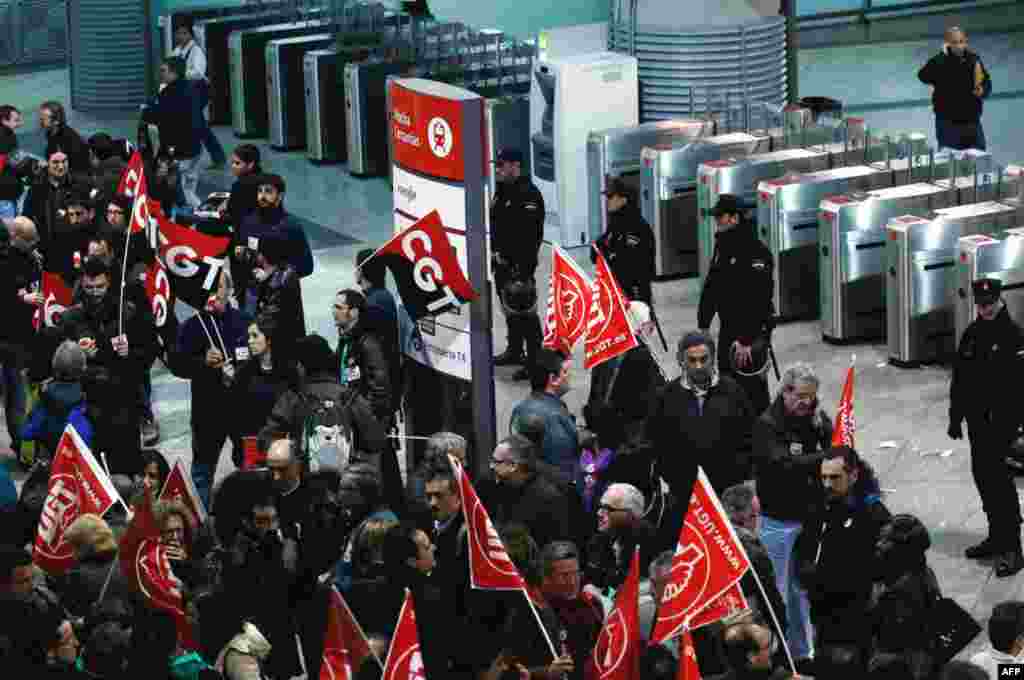 Protestors stand near the gantries of Madrid's Atocha railway station in Spain March 29, 2012. (Reuters)