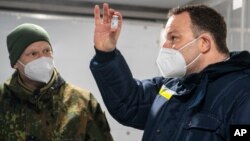 Jens Spahn, ministre de la Santé Allemand, avec Julian Brederlow, pharmacien principal, dans un conteneur réfrigéré à la pharmacie de la Bundeswehr à Quakenbrueck, le 14 mai 2021.