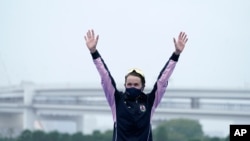 Gold medalist Flora Duffy of Bermuda celebrates during a medal ceremony for the women's individual triathlon competition at the 2020 Summer Olympics, July 27, 2021, in Tokyo, Japan. 