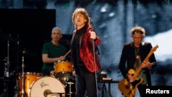 Mick Jagger (tengah), Charlie Watts (kiri) dan Keith Richards dari band the Rolling Stones saat tampil di konser mereka di Abu Dhabi (21/2).