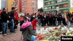 A person kneels during a gathering to honor Dilan Cruz, a teenage demonstrator who died after being injured by a tear gas canister during an initial strike last week, in Bogota, Colombia, Nov. 26, 2019.