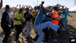 
Les mineurs viennent commémorer la mémoire des mineurs de platine tués il y a un an alors qu'ils étaient en grève à Marikana , Afrique du Sud , le 16 août 2013.
