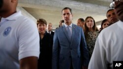 Accompanied by his wife Fabiana Rosales, center right, Venezuela's self proclaimed president Juan Guaido, arrives for a meet with university students at the Central University of Venezuela, in Caracas, Venezuela, Friday, Feb. 9, 2019. 