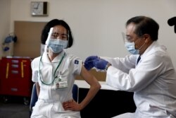 17일 일본 도쿄메디컬센터에서 의료진이 신종 코로나바이러스 백신 주사를 맞고 있다.