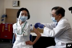 17일 일본 도쿄메디컬센터에서 의료진이 신종 코로나바이러스 백신 주사를 맞고 있다.