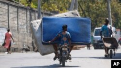 Residentes transportan colchones en una motocicleta en Puerto Príncipe, Haití, el lunes 4 de marzo de 2024.