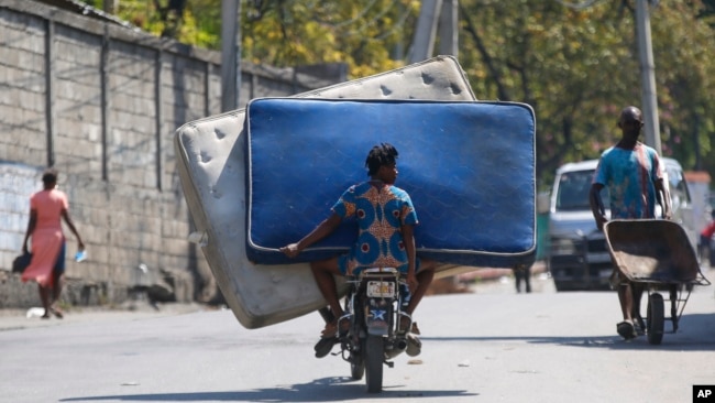 Residentes transportan colchones en una motocicleta en Puerto Príncipe, Haití, el lunes 4 de marzo de 2024.