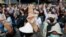 Anti-government protesters raise a three-fingered salute, a symbol of resistance, as they march from Democracy Monument to government house in Bangkok, Thailand, Oct. 14, 2020.