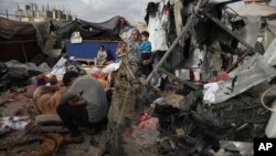 Pengungsi Palestina memeriksa tenda mereka yang hancur akibat pengeboman Israel, di samping fasilitas UNRWA di sebelah barat kota Rafah, Jalur Gaza, pada 28 Mei 2024. (Foto: AP)