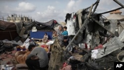 Người Palestine bên khu lán trại bị phá hủy ở phía tây Rafah.