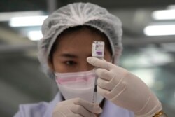 FILE - A health worker prepares a shot of the AstraZeneca COVID-19 vaccine for people at the Central Vaccination Center in Bangkok, Thailand, July 22, 2021.