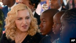 Madonna (kiri), duduk bersama anak-anak adopsinya, David, Stella dan Mercy pada upacara pembukaan Pusat Bedah dan Perawatan Intensif anak, The Mercy James Institute, di Kota Blantyre, Malawi, 11 Juli 2017.