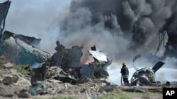 FILE - African Union Mission in Somalia soldiers attempt to extinguish the fire at the site of an airplane crash in Mogadishu, Somalia. (AMISOM) 