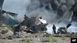 Bombeiros da missão de manutenção das paz da União Africana tentam combater o incêndio provocado pela queda do avião 