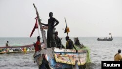 Des pêcheurs débarquent leur bateau sur la plage près de la ville côtière de Joal-Fadiouth, au Sénégal, le 10 avril 2018.