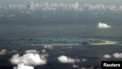 FILE - An aerial photo taken though the window of a Philippine military plane shows the land reclamation by China on Mischief Reef in the Spratly Islands in the South China Sea, west of Palawan, Philippines, May 11, 2015.